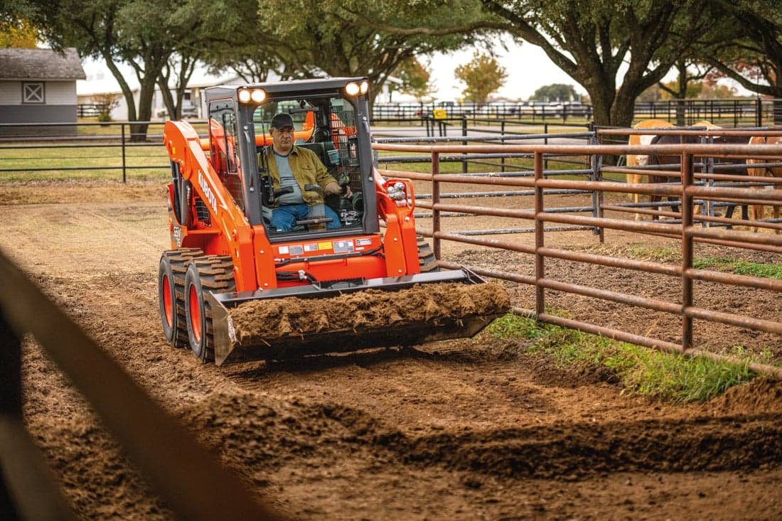 Man using skid steer to move dirt