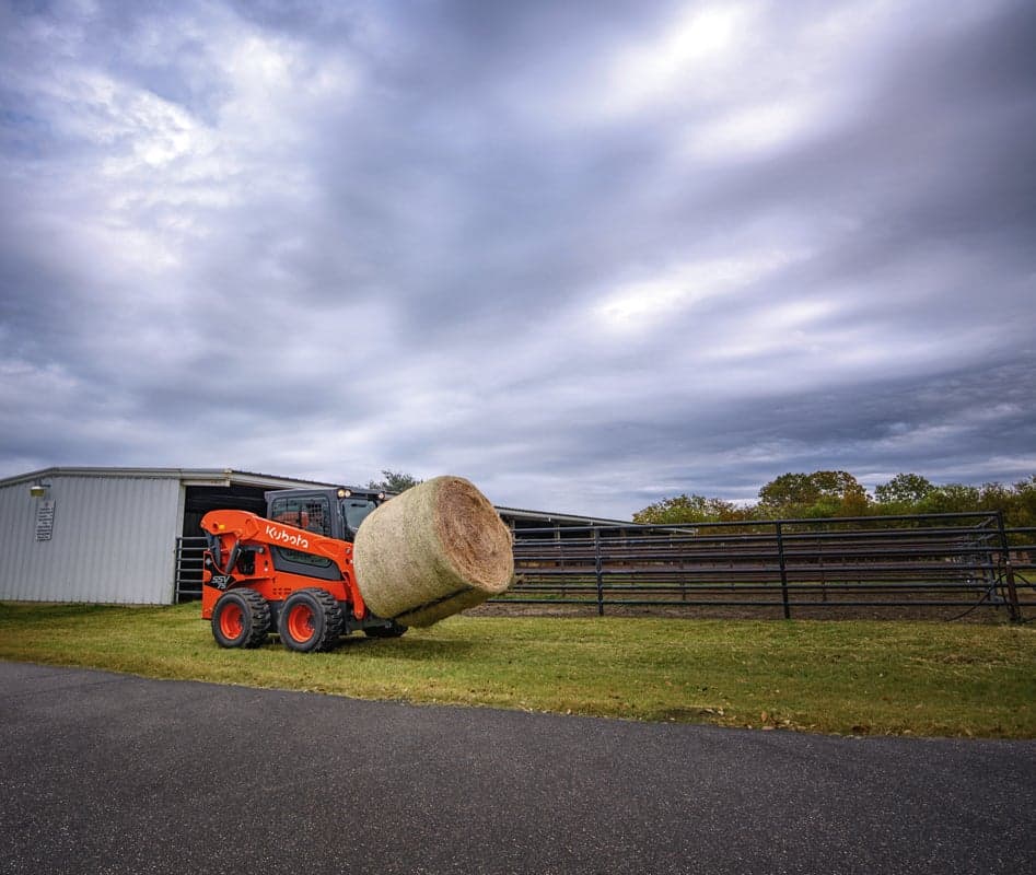 Skid steer moving hay bale